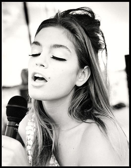 Cindy Crawford Singing Country Western in Cheyenne Wyoming. 1989 by Arthur elgort, the model in a pailette top singing into a microphoen, eyes closed