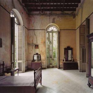 Home of Mercedes Alfonso, Linea 508 (between D and E), Vibora, Havana. 1997 by Robert Polidori, bedroom interior with old furniture in dark wood, orange walls