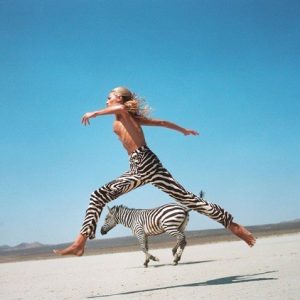 Beauty and Beast II by Michel Comte, Helena Christensen jumping in Zebraprint pants, with Zebra