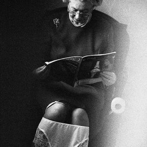 the Queen on the loo by Alison Jackson, Queen lookalike sitting on the toilet reading a magazine