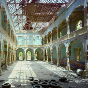 Temple of David (Beirut), 1996 by robert polidori, interior of a broken down renaissance basiliqua with light blue walls, old tires lying around