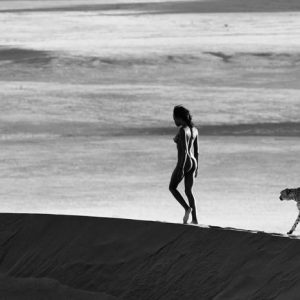 Girls on film by David Yarrow, nude model walking on a dune, a cheetah following her