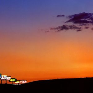 Vegas by Albert Watson, a row of Billboards in front of an orange sunset sky