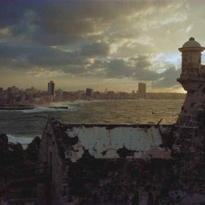 A view of Havana from the Castillo del Morro, by Robert Polidori, an old castello in the foreground and the coastlin of Havanna city in the background