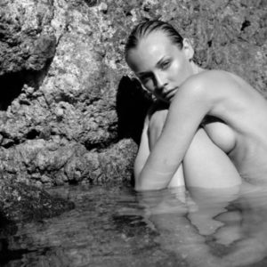 Diane Kruger by Antoine Verglas, the nude actress crouching in a natural pool betwenn rocks