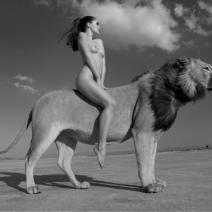 Angela Rides the Lion by Sylvie Blum, nude model sitting on a lions back in the desert