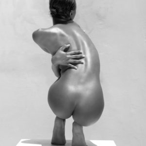 Chocolate Girl III - Vel posing on white box by Sylvie Blum, nude model crouching, from the back