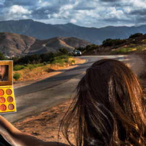 Desert Love by David Drebin, model on the roadside touching up her makeup in a small mirror