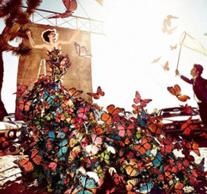 Butterfly by Kristian Schuller, model in a dress made of butterflys and a man with a landing net trying to catch the butterflys