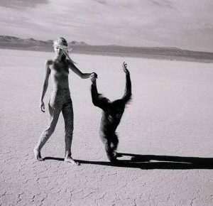 Beauty and Beast 1996 by michel comte, nude model and monky walking hand in hand through the desert