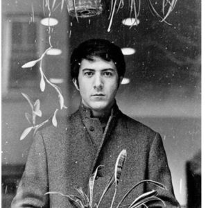 Dustin Hoffman by Terry O'Neill, the actor in a woolcout looking through a window and plants