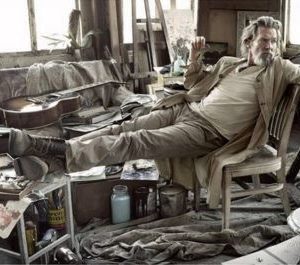 Jeff Bridges by Mark Seliger, the actor dressed in brown and beige in a meassy artstudio