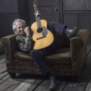 Keith Richards with guitar by Mark Seliger, the musicien lounging on a sofa with his guitar