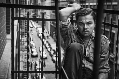 Leonardo Dicaprio, New York, NY, 2015 by Mark Seliger, the actor in a jeans shirt sitting on a cast iron balcony above a street