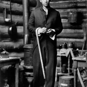Will Smith, Big Sky Ranch, CA, 1997 by Mark Seliger, the actor in an oversized suit and tophat, carrying a cane in a loghouse kitchen