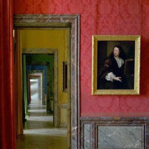 Salles du XVII, Aile du Nord by Robert Polidori, enfilade with marble doorframes and bright colored wallpaper, a portrait in goldframe on a red wall