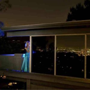 Waiting for Love by Guido Argentini, model in turquoise gown standing on a terrace
