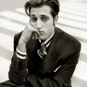 Johnny Zander - New York City 1996 by Albert Watson, black and white portrait of the actor in a black suit and striped shirt