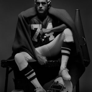 Mike - from the series Twelve - New York 1977, male sitting in football dress and hair rollers, holding binoculars