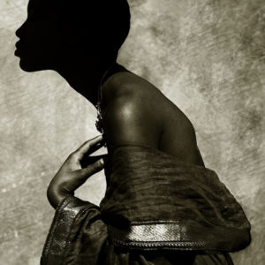 Naomi Campbell - Palm Springs 1989 by Albert Watson, the model in sideprofile, wearing an offshoulder blouse and necklace