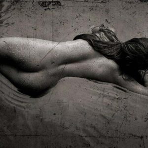 Erotic Nude 2010 #5280 by Andreas H. Bitesnich, a nude model lying in water, her back turned to the camera