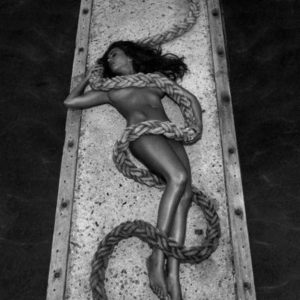 Iveta - Lesbos by Andreas H. Bitesnich, model lying on a jetty with a rope wrapped around and covering her nude body