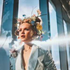 Hadley Robinson III by Guy Aroch, the actress in a light blue jacket and flowercrown