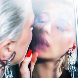 Smoke and mirrors by David Drebin, model with white hair and red nails breathing at a fogged up mirror