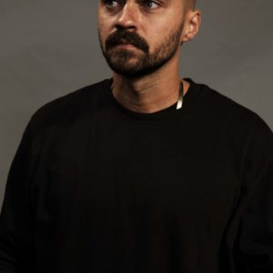 Jessie Williams by Marc Baptiste, portrait of the actor in a black jumper