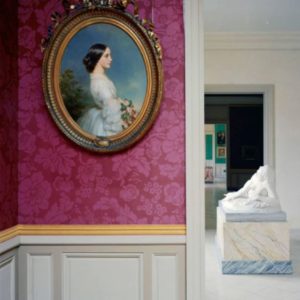 Carmen-Ida Aguado by Franz Xaver Winterhalter by Robert Polidori, oval portrait of a woman in gold frame on a pink wall, a marble statue in the background