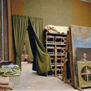 Salle de L'Afrique, No. 4 by Robert Polidori, interior view with green and yellow wallpapers and green doorway curtains and antique paintings and stools stored