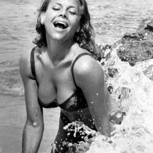 Honor Blackman by Terry O'Neill, the actress in a bikini splashing in the waves at the beach
