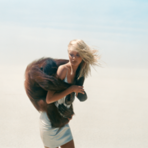 Michel Comte's Beauty and Beast series, model in silver dress carrying a monkey on her back in the desert