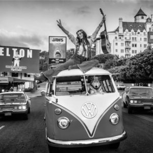 Summer of '75 in b&w by David Yarrow, VW Bus driven by Dog while a model with guitar is sitting on top