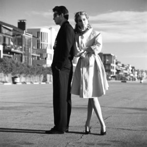 Julia Roberts und Dylan McDermont, the actress in a white coat leaning against the actors back, who is wearing a black suit