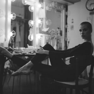 Wilhelmina Frankfurt, New York City Ballet 1979 by Arthur Elgort, ballerina in black leotard sitting backstage