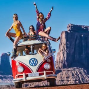 And the party never ends by David Yarrow red VW Bus with four girls in hippie clothing