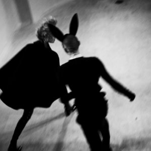 Bunny Run by Ellen von Unwerth, two figures in black, ne with bunny mask, running