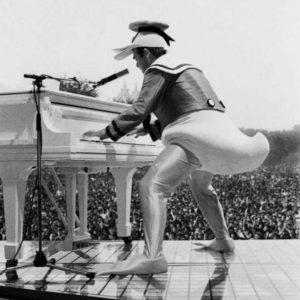 Elton John by Roxanne Lowit, black-and-white fine art photography of singer playing piano in duck costume