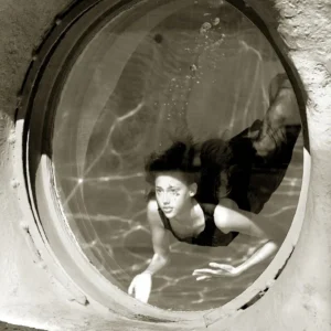 Albert Watson, Estella Warren, Underwater, Window, Eerie, black and white, black and white photography, limited edition, fine art photography, model, swimming, diving, surrealsim, round window, light, reflections